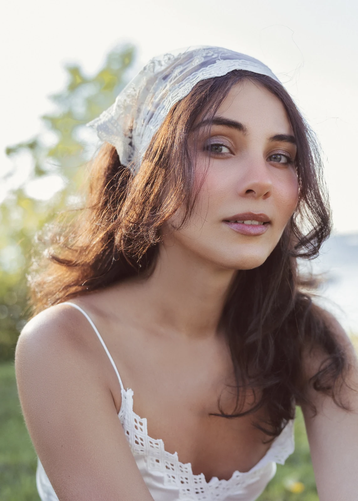 Outdoor portrait from a natural-light session — grass, trees, and golden-hour light.