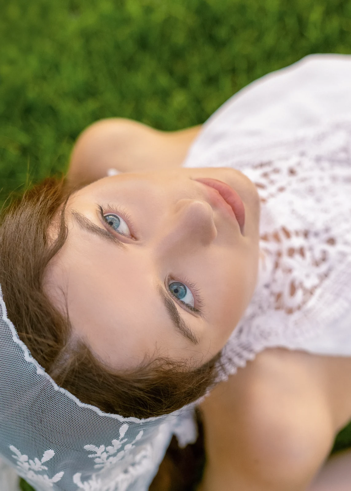 Outdoor portrait from a natural-light session — grass, trees, and golden-hour light.