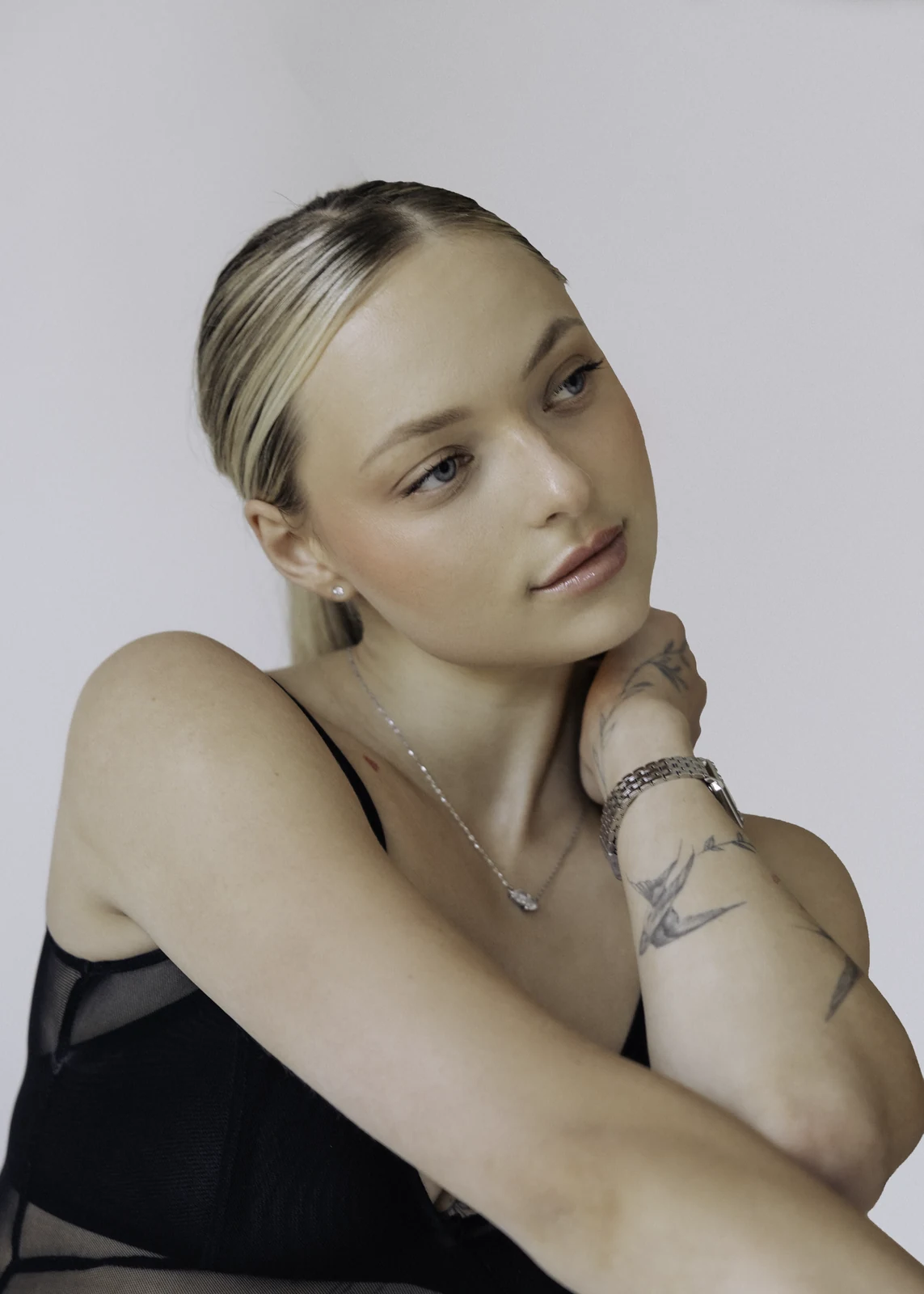 Studio portrait against a seamless backdrop — controlled lighting, editorial styling.