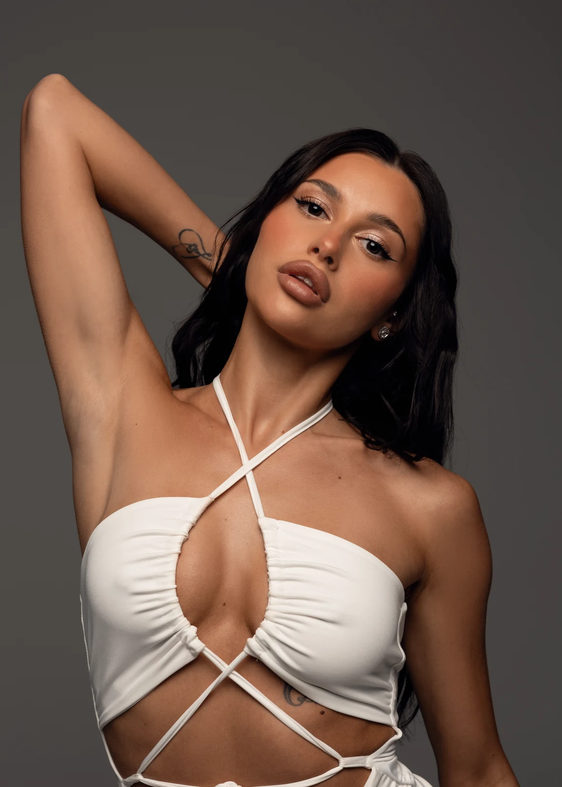 Studio portrait against a seamless backdrop — controlled lighting, editorial styling.