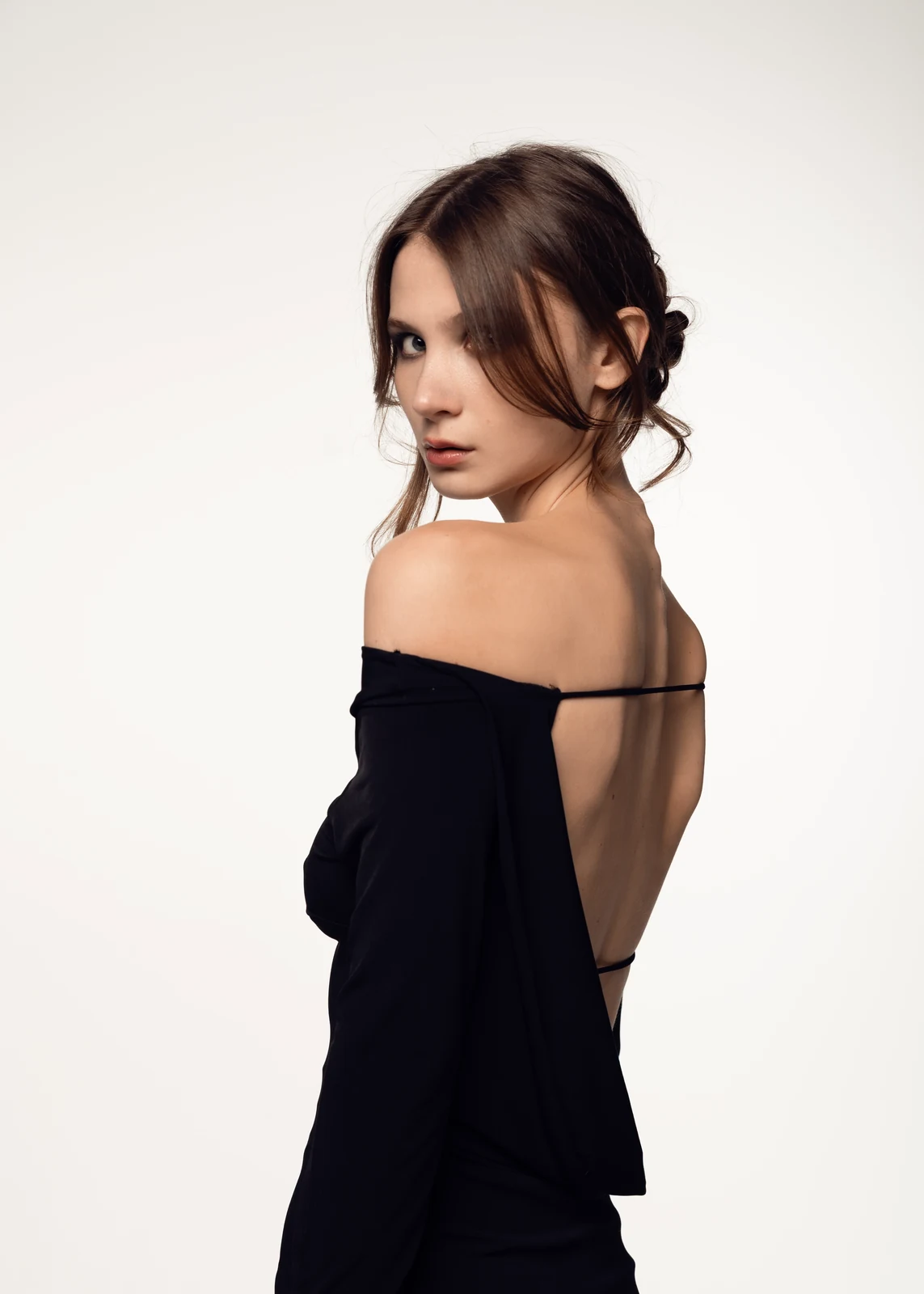 Studio portrait against a seamless backdrop — controlled lighting, editorial styling.